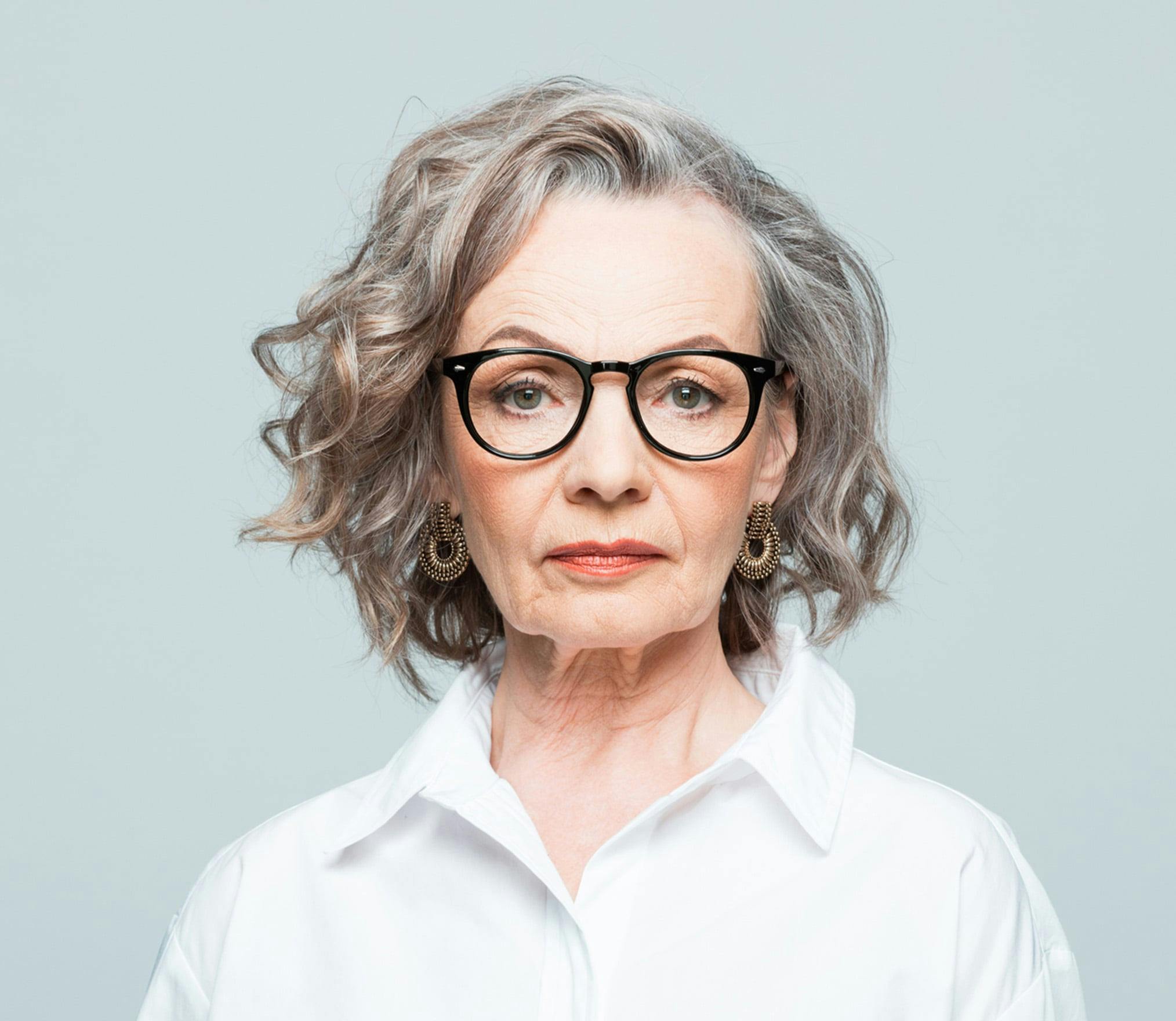 there is a woman with glasses and a white shirt posing for a picture