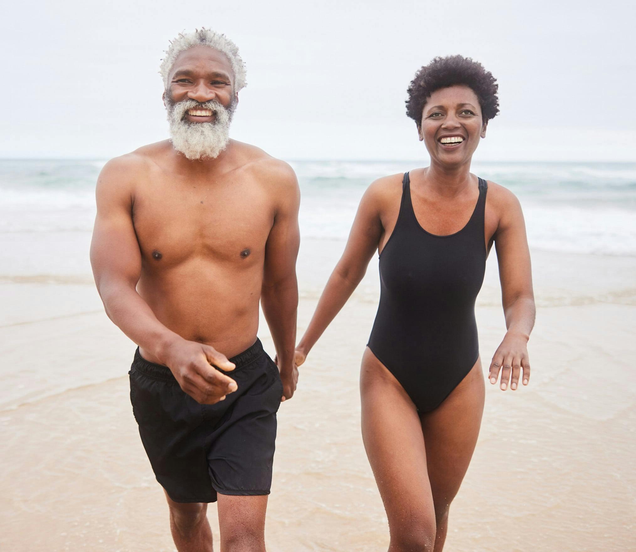 Happy couple walking along beach