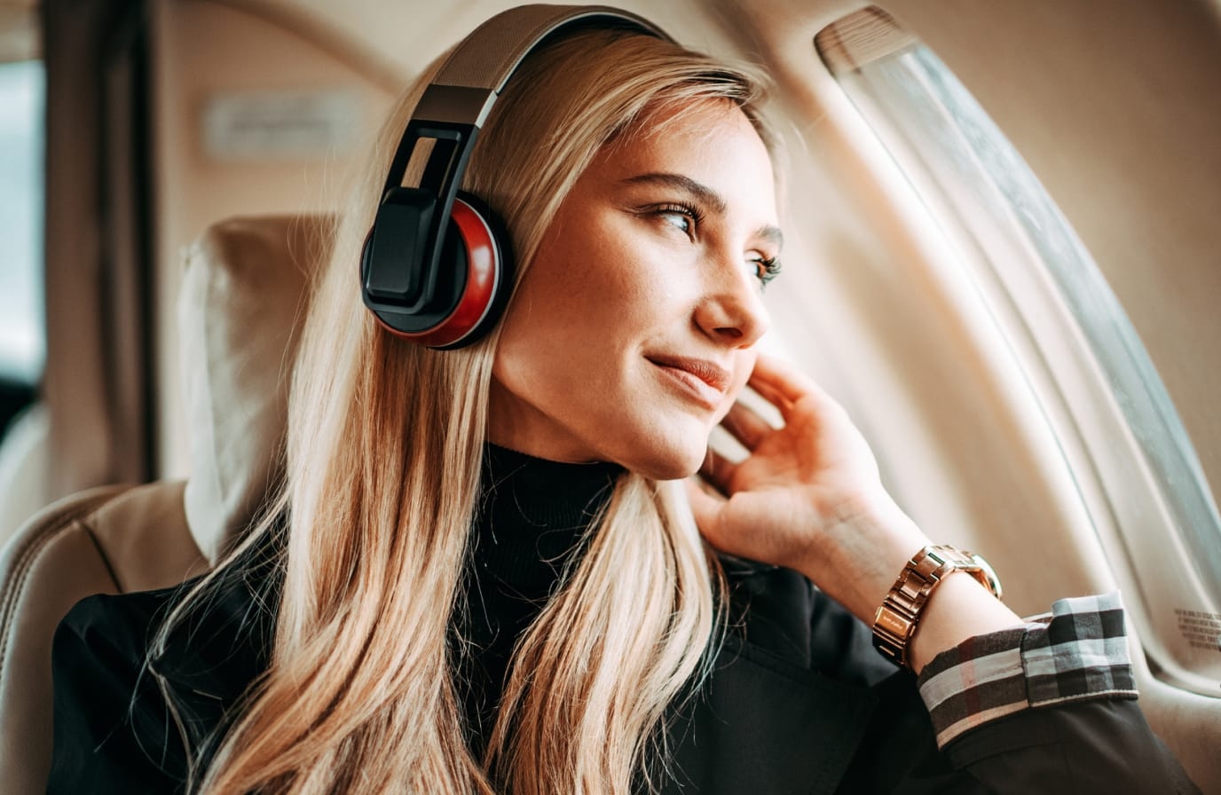 Smiling woman on Plane wearing headphones