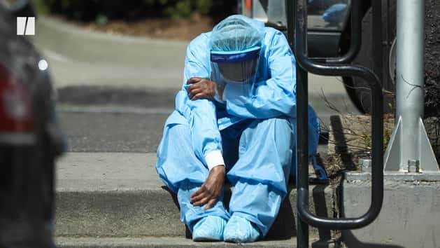 man in blue hazmat suit sitting on street step