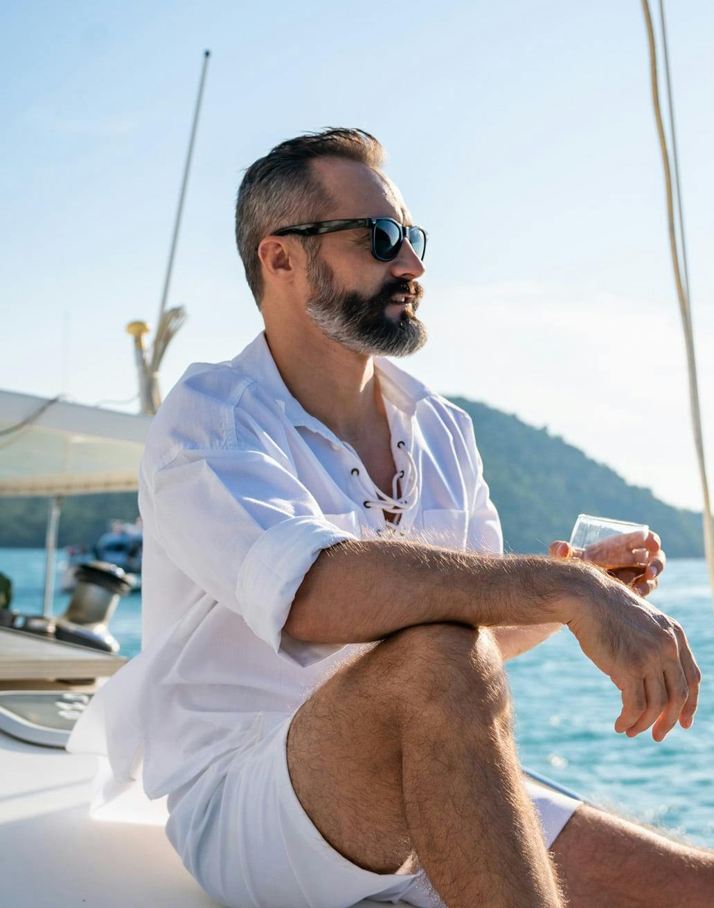 man sitting on a boat with a glass of wine