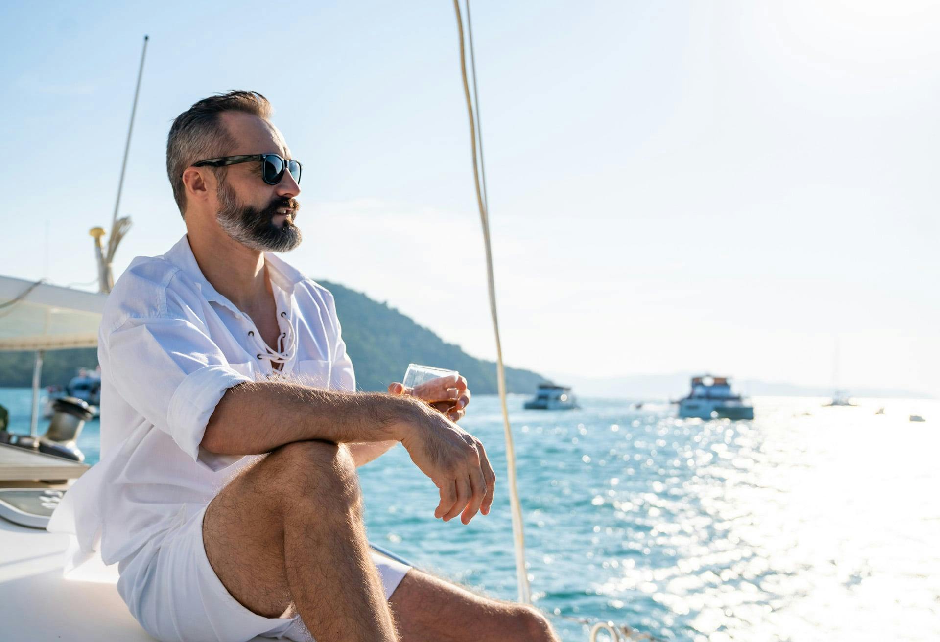 Man sitting on boat with glass of wine
