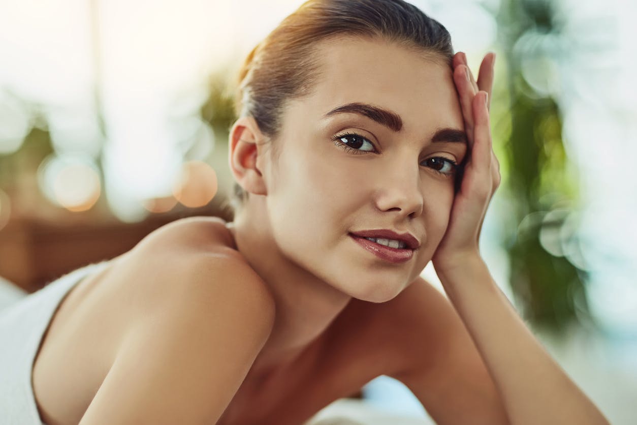 Woman holding face in sun light