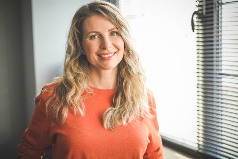 woman with blonde hair wearing an orange shirt