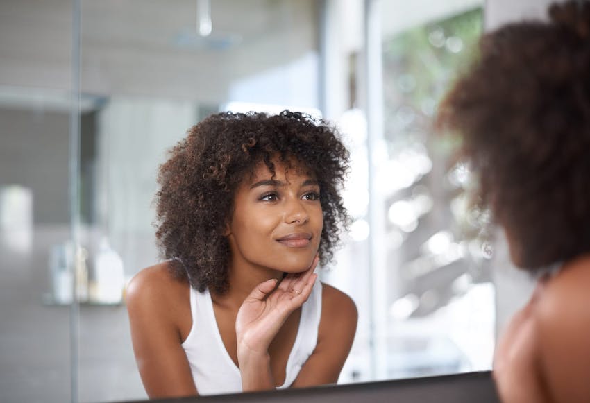 Woman smiling and looking into mirror