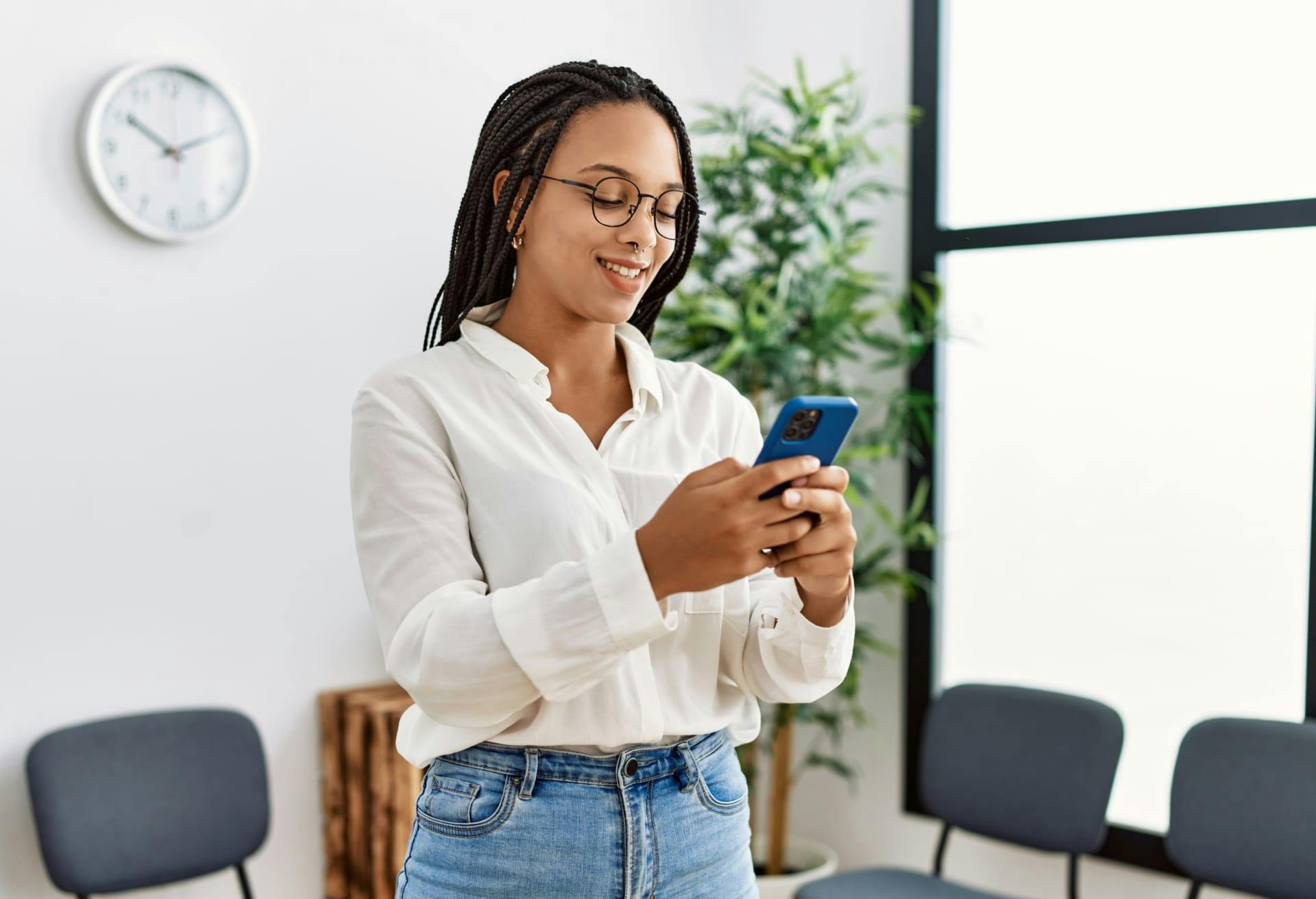 woman smiling and looking at phone