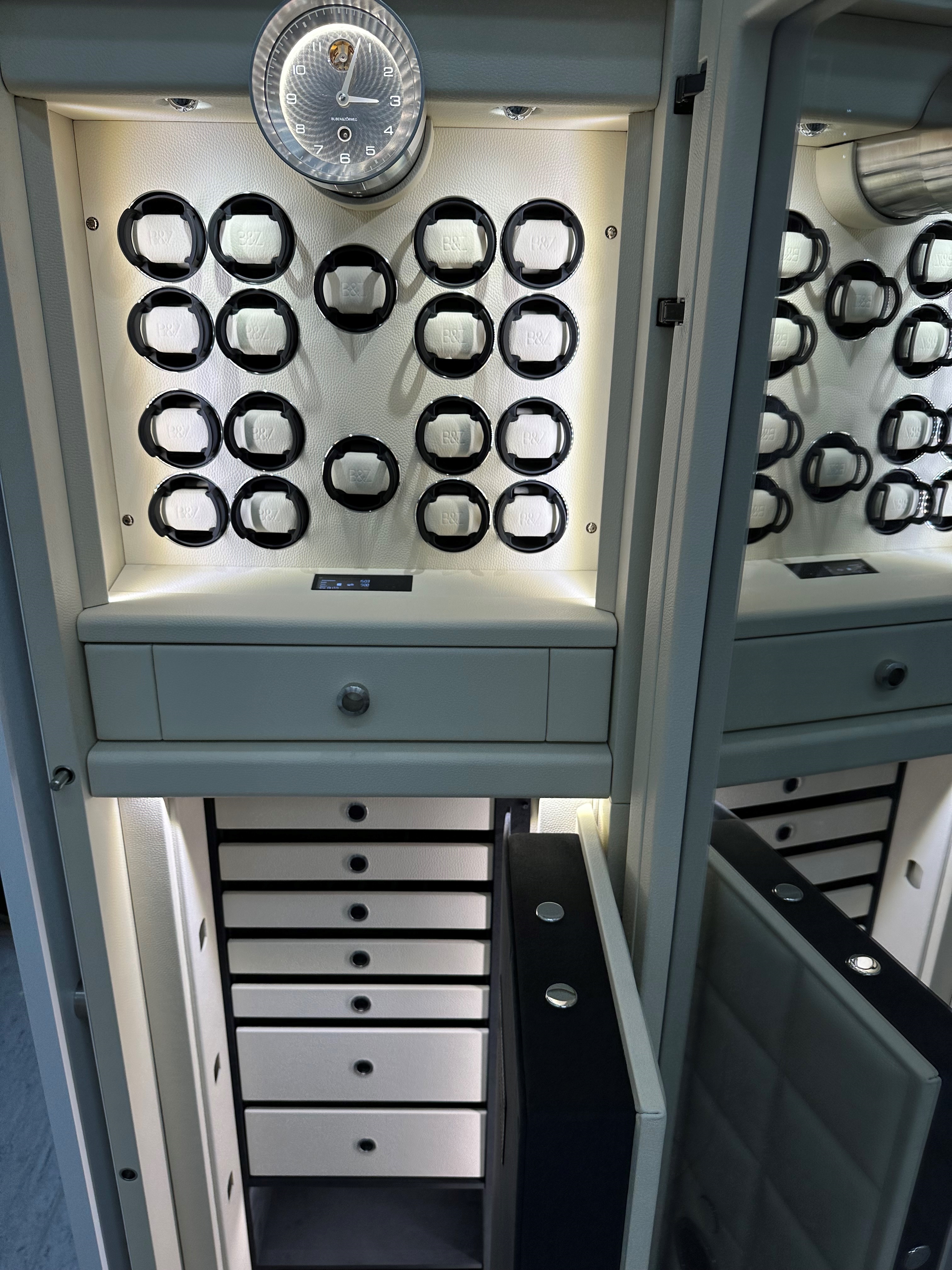 打開 BUBEN&ZORWEG VISION 高安全性保險箱，內部裝有照明燈，配備腕錶上鏈器、Signature Clock 和優雅的白色儲物抽屜。 — BUBEN&ZORWEG