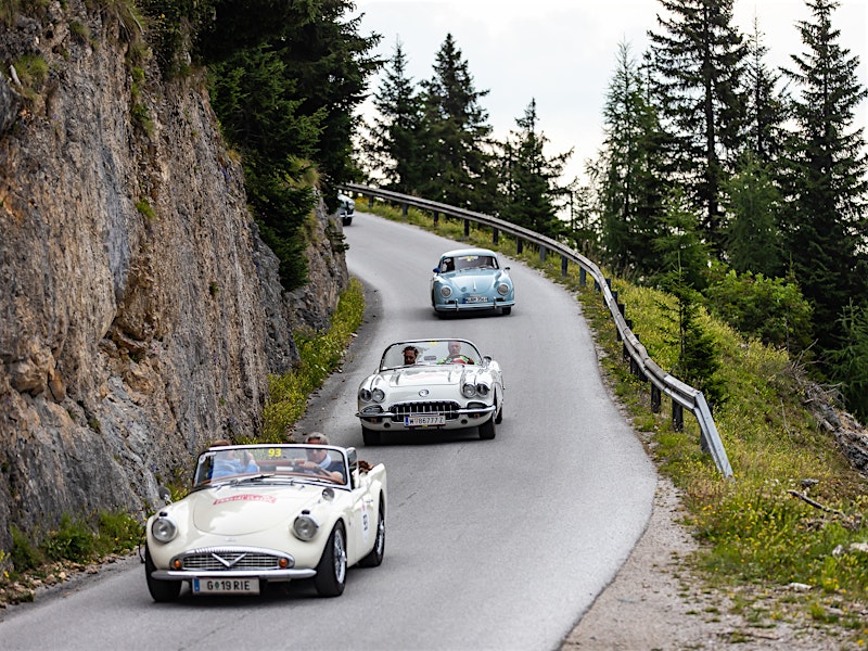 Classic cars driving on a winding mountain road during Ennstal-Classic rally — BUBEN&ZORWEG