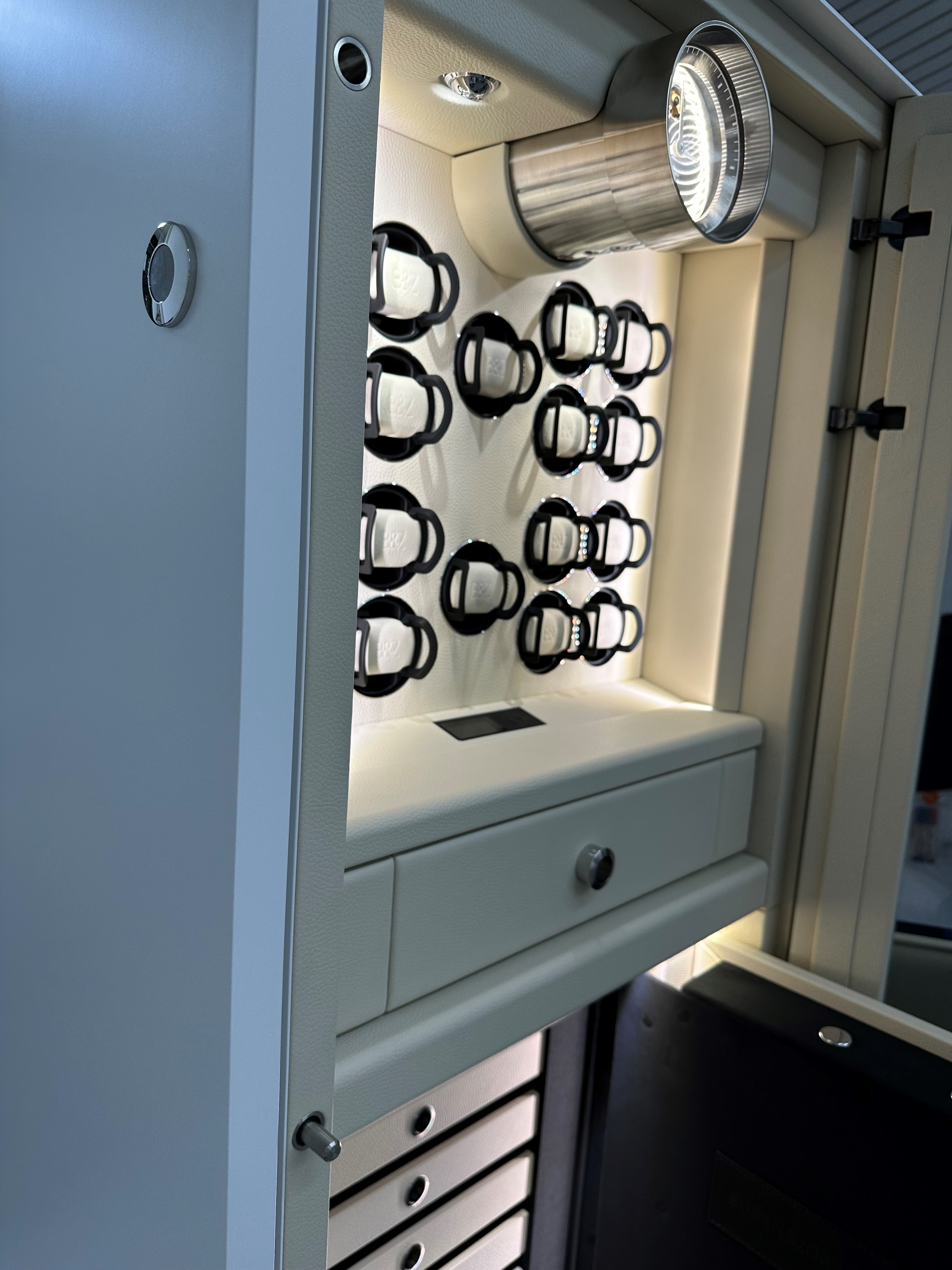 打开 BUBEN&ZORWEG VISION 高安全性保险箱，内部装有照明灯，设有手表上发条器、签名时钟和优雅的白色储物抽屉。 — BUBEN&ZORWEG