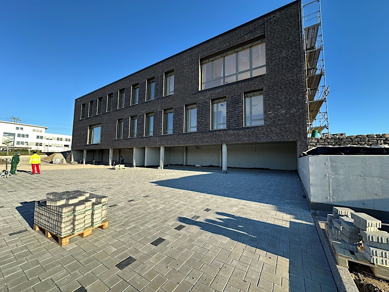New building with dark facade and paved courtyard — BUBEN&ZORWEG