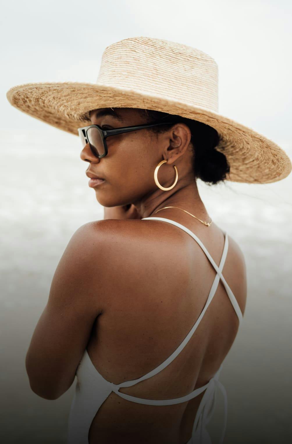 A woman with a big had and bathing suit on