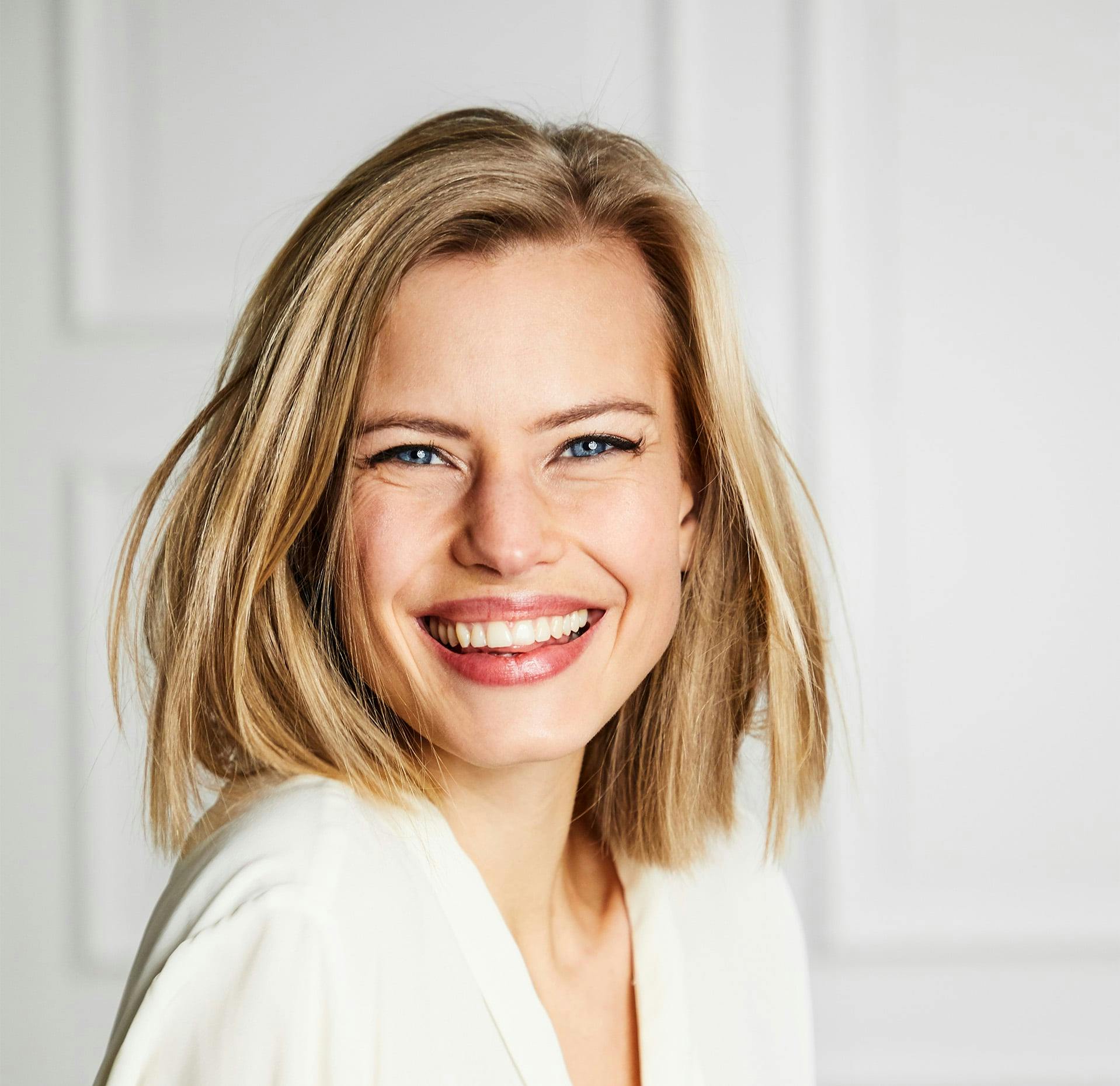 woman with blonde shoulder length hair smiling