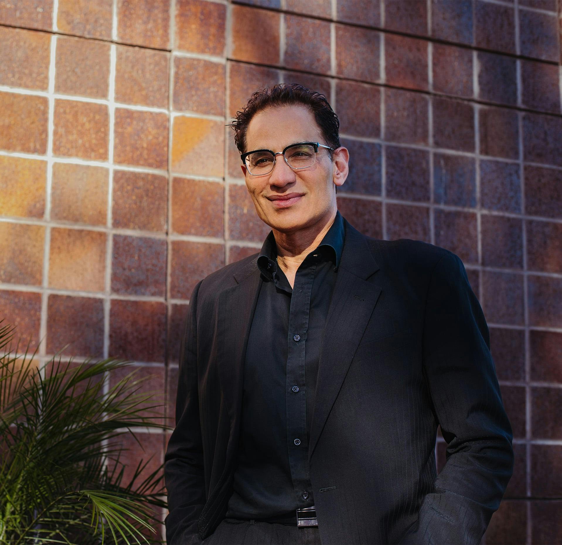 Dr. Moradi with a brown wall behind him
