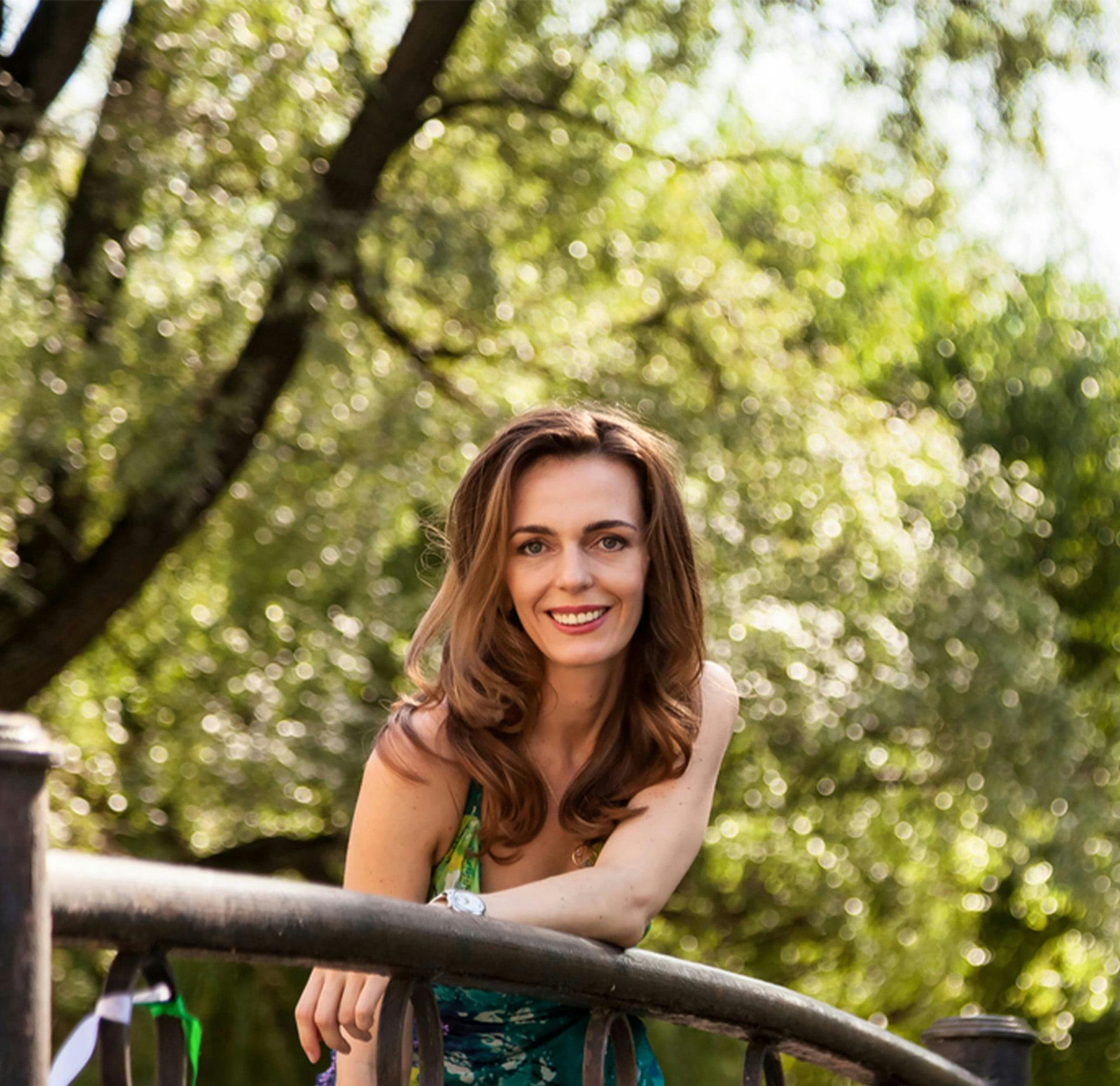 woman with brown hair and trees in the background