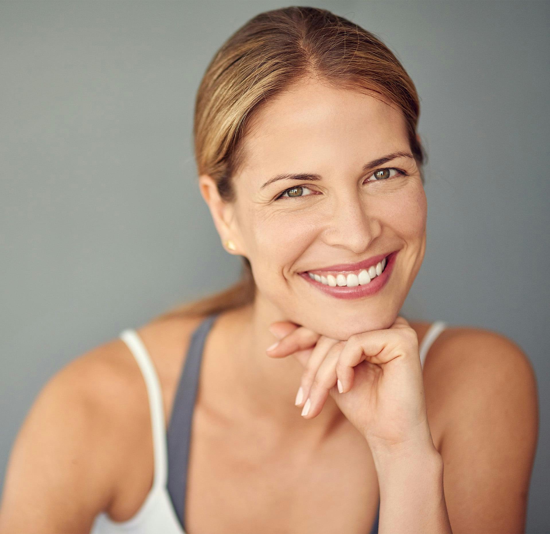 woman with her hair pulled back and white tank top on