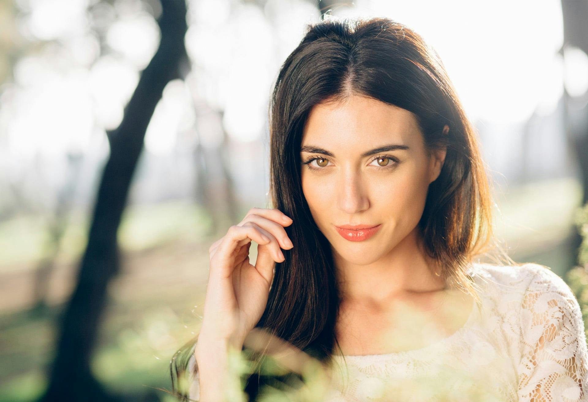 woman with brown eyes and brown hair and trees in the background