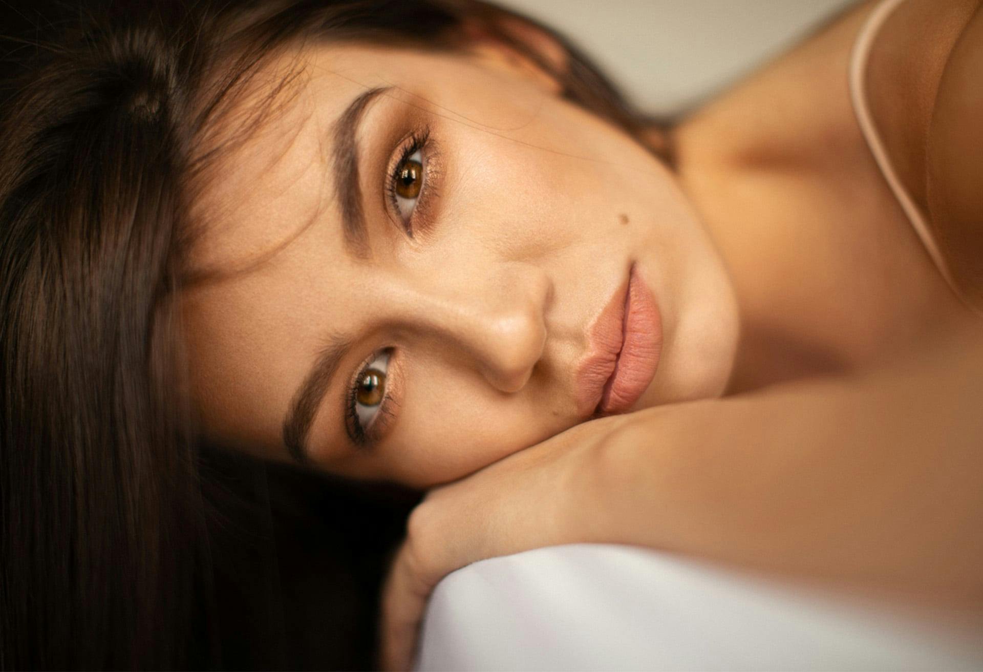 woman with brown hair laying on her hand