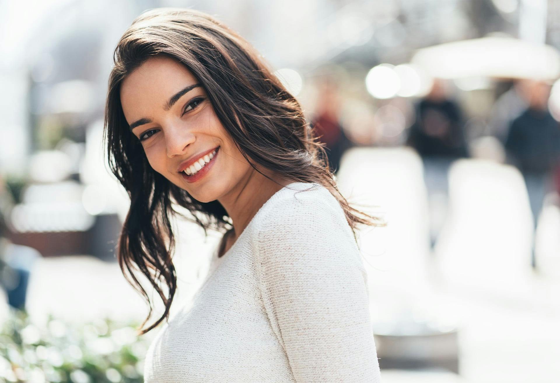 woman with brown hair and white sweater on