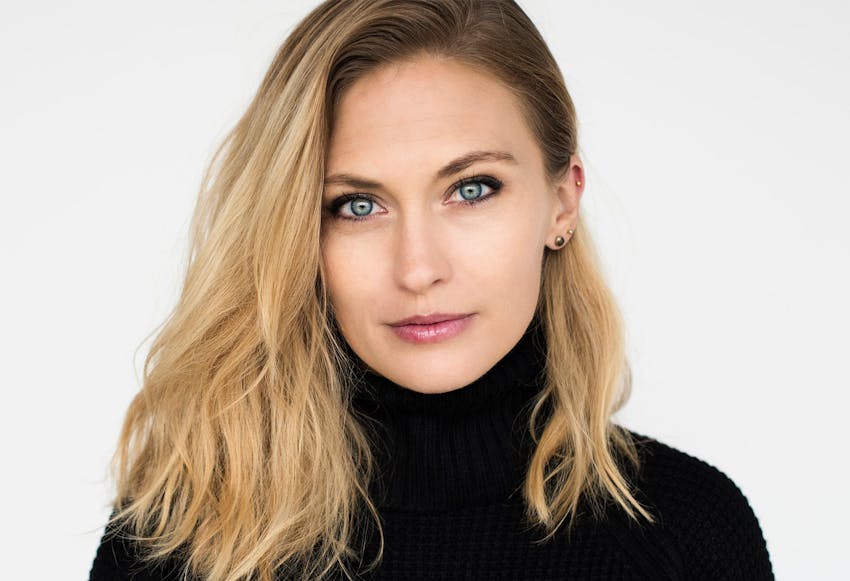 woman with blonde hair & a black turtle neck on