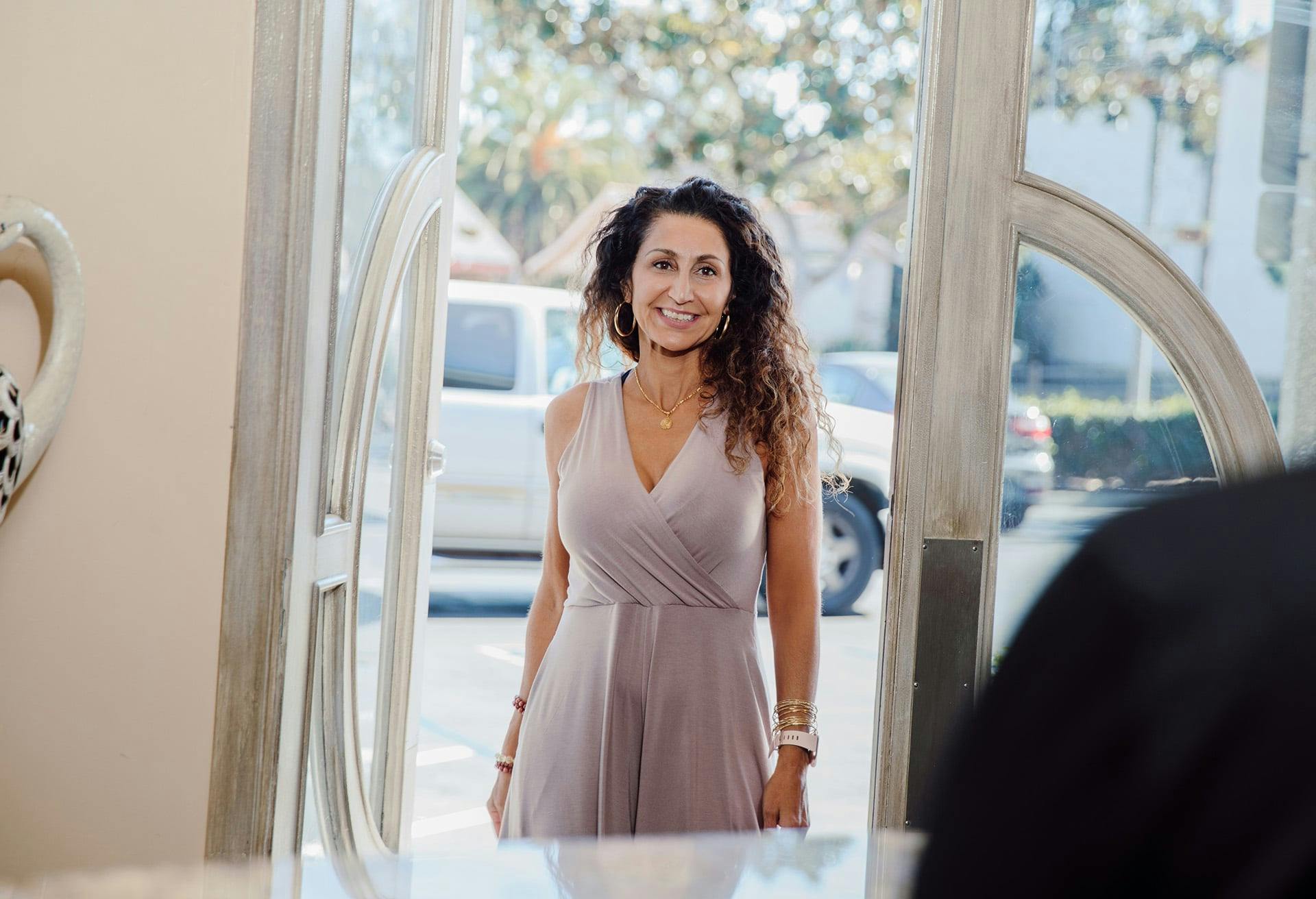 woman in a dress walking through the door