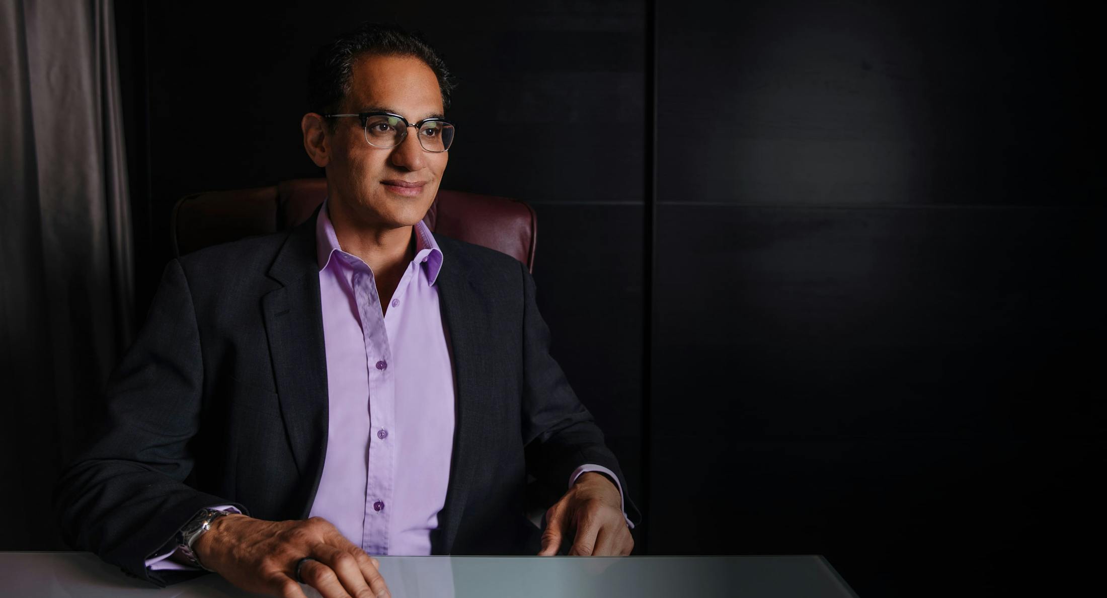 Dr. Moradi in a suit sitting in a chair