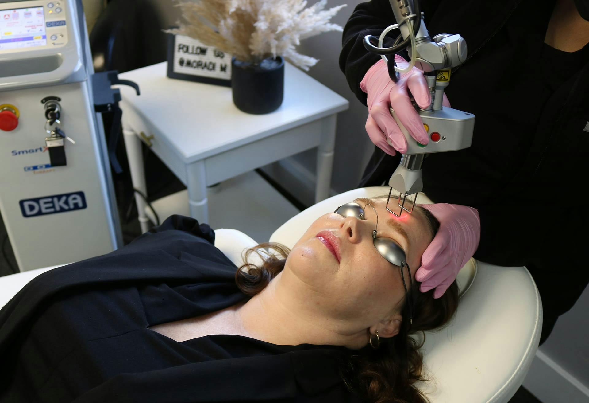 woman laying down on the chair with a laser device on her skin