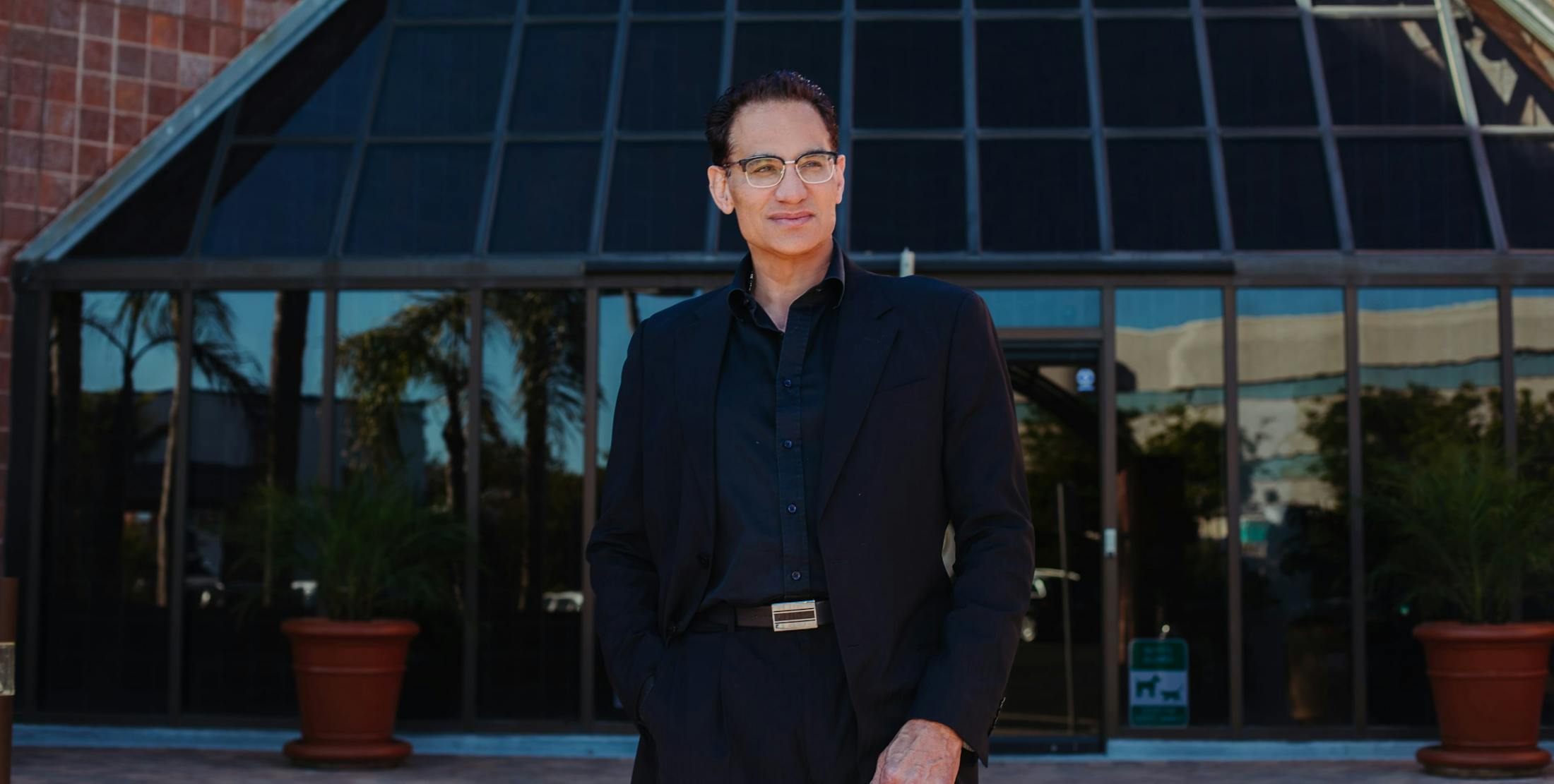 Dr. Amir Moradi in a suit in front of his office