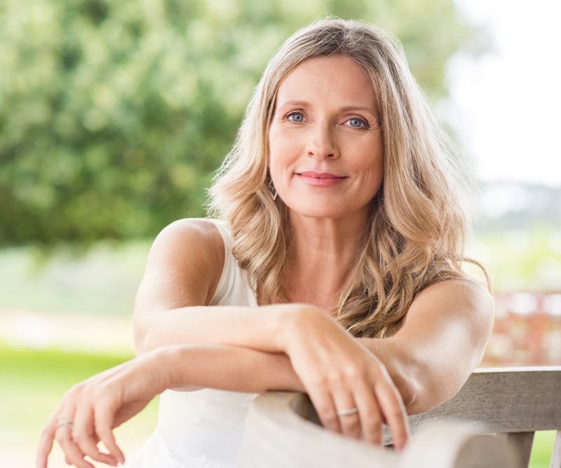 Woman sitting and resting arms on chair