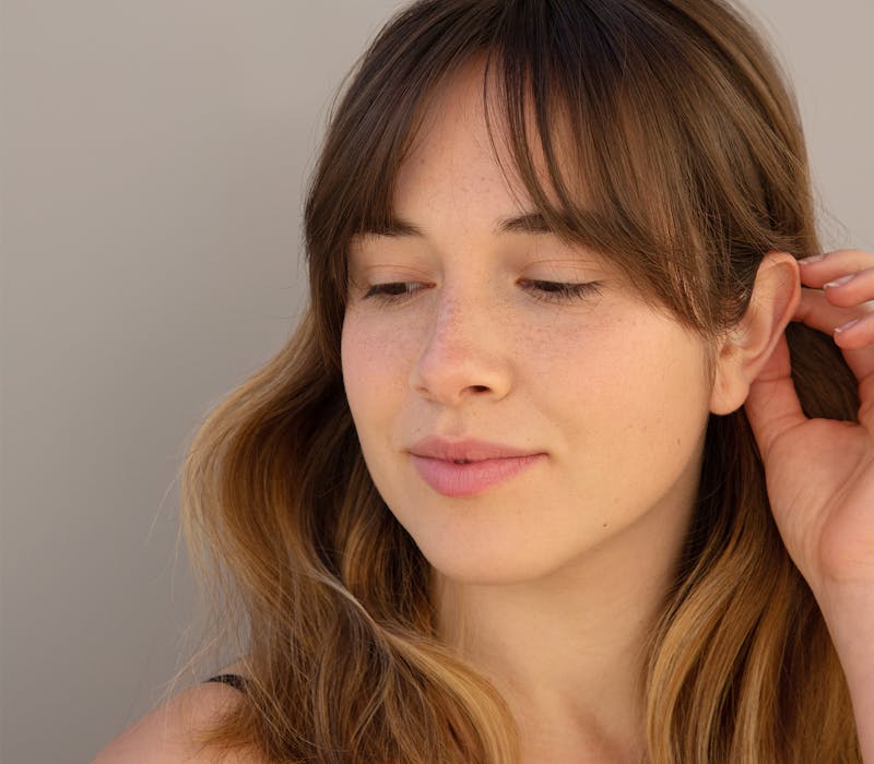 Woman tucking her hair behind her ear