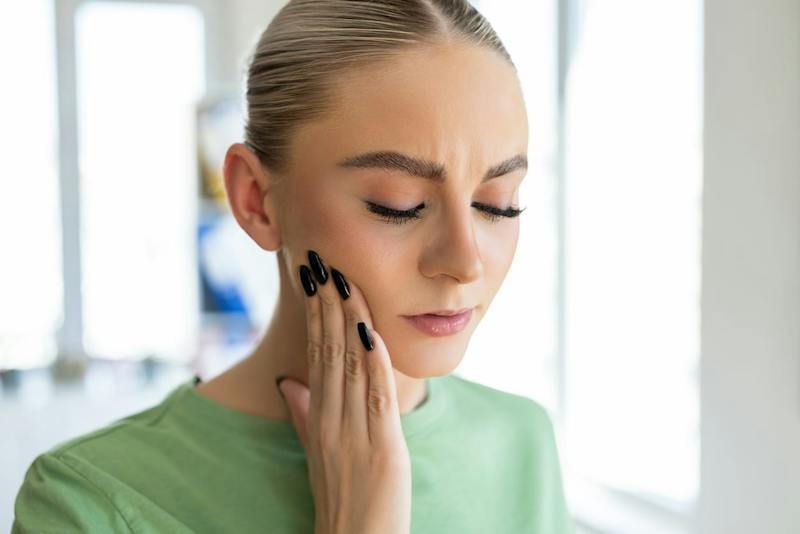woman feeling her jaw