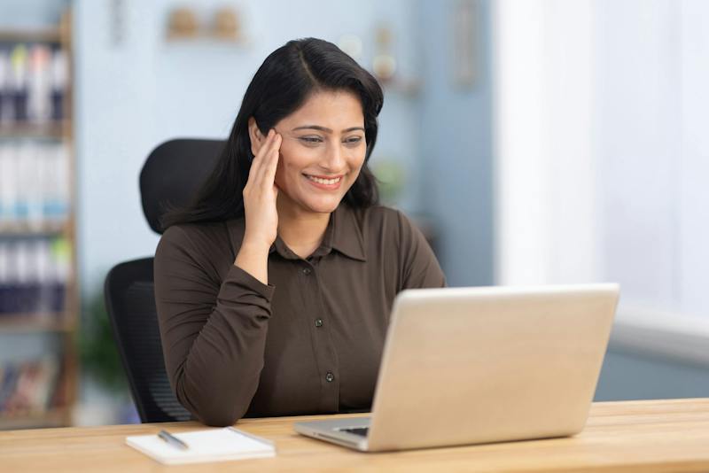 Woman smiling while looking at laptop computer