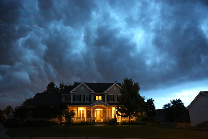 House with lights on during a cloudy and stormy night.