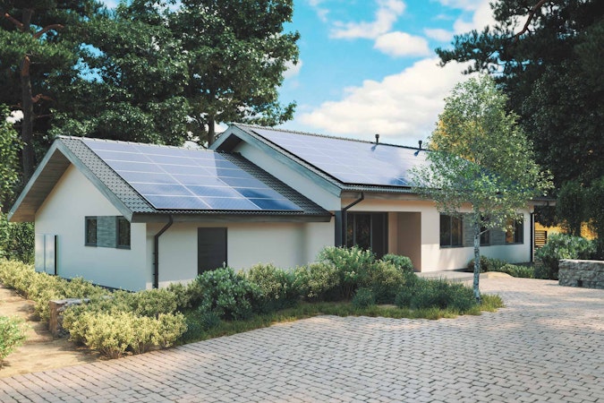 Solar backup for home installed on the roof of a white house in cobble driveway with a blue sky.