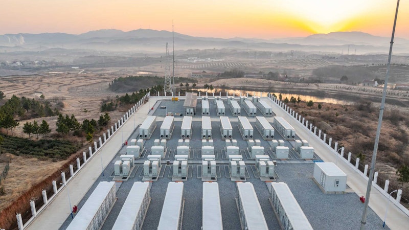 Commercial battery storage overlooking the sunset on a mountian range.