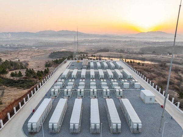 Commercial battery storage overlooking the sunset on a mountian range.