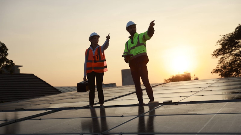 Solar workers installing a home solar system at sunset.