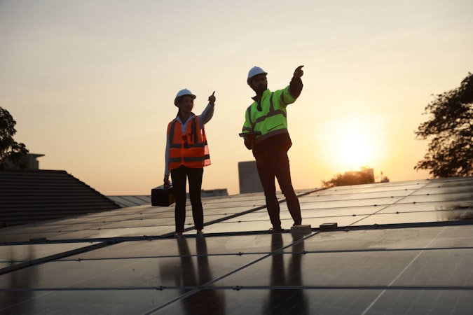 Solar workers installing a home solar system at sunset.