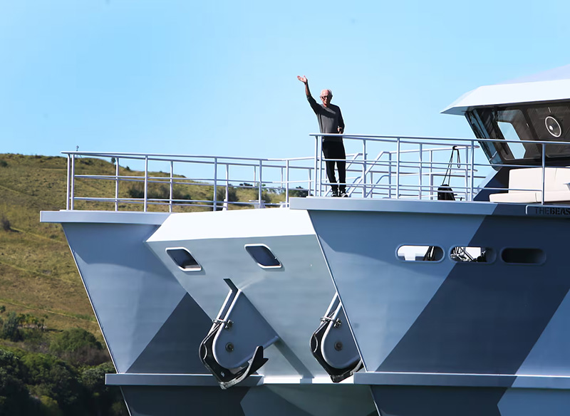 Sir Michael Hill waving from the front deck of his yacht