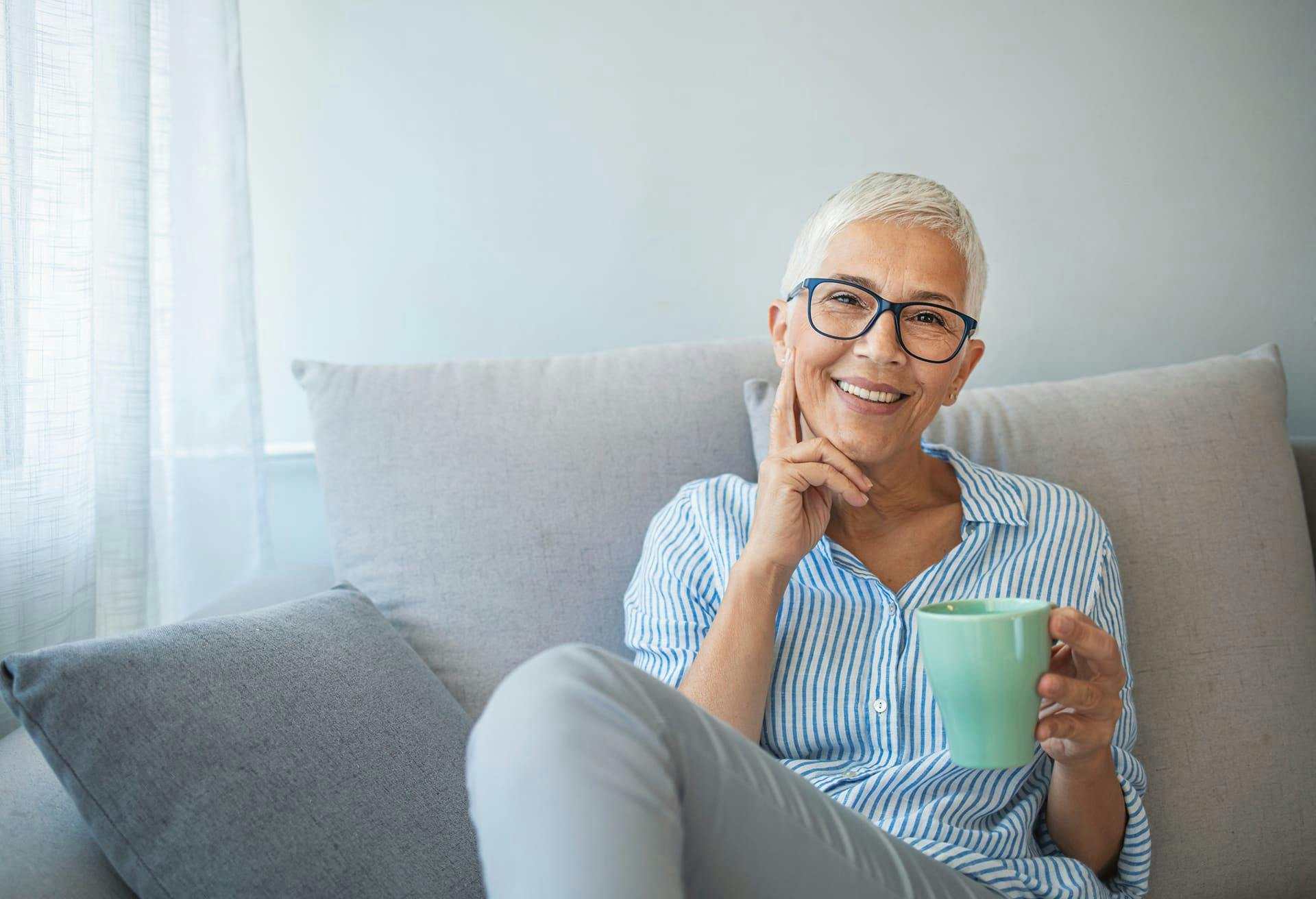 Older Woman Sitting on the Couch with a Cup of Coffee