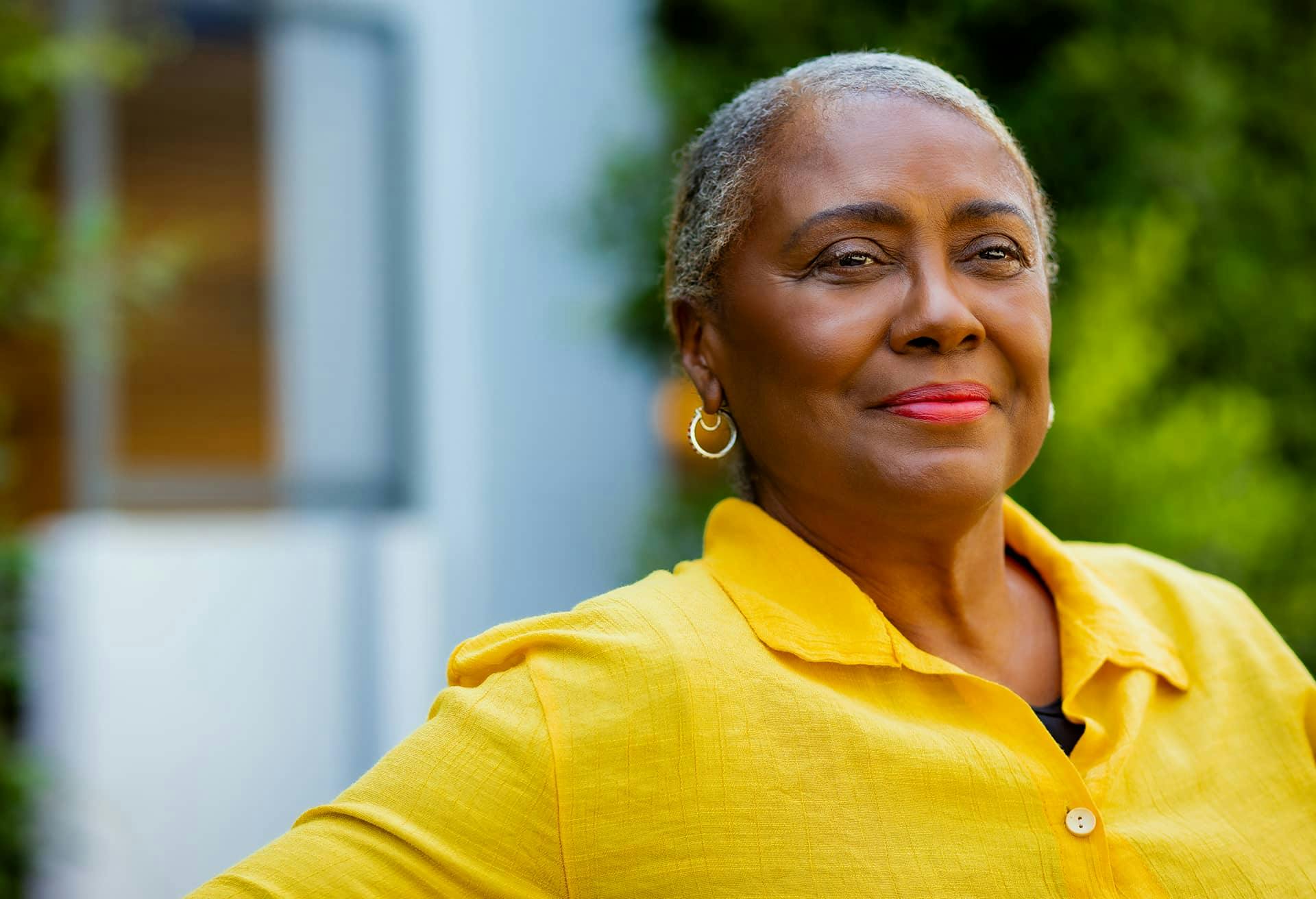An older woman in a vibrant yellow top