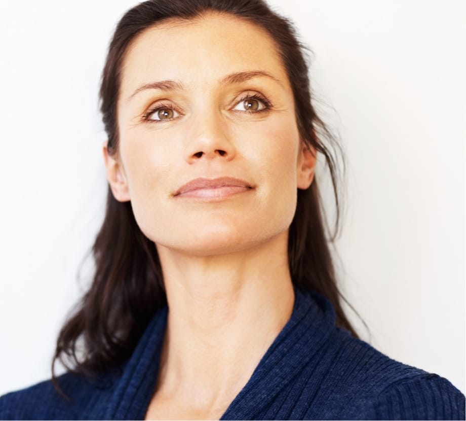 Beautiful middle aged woman with dark hair wearing a dark blue top