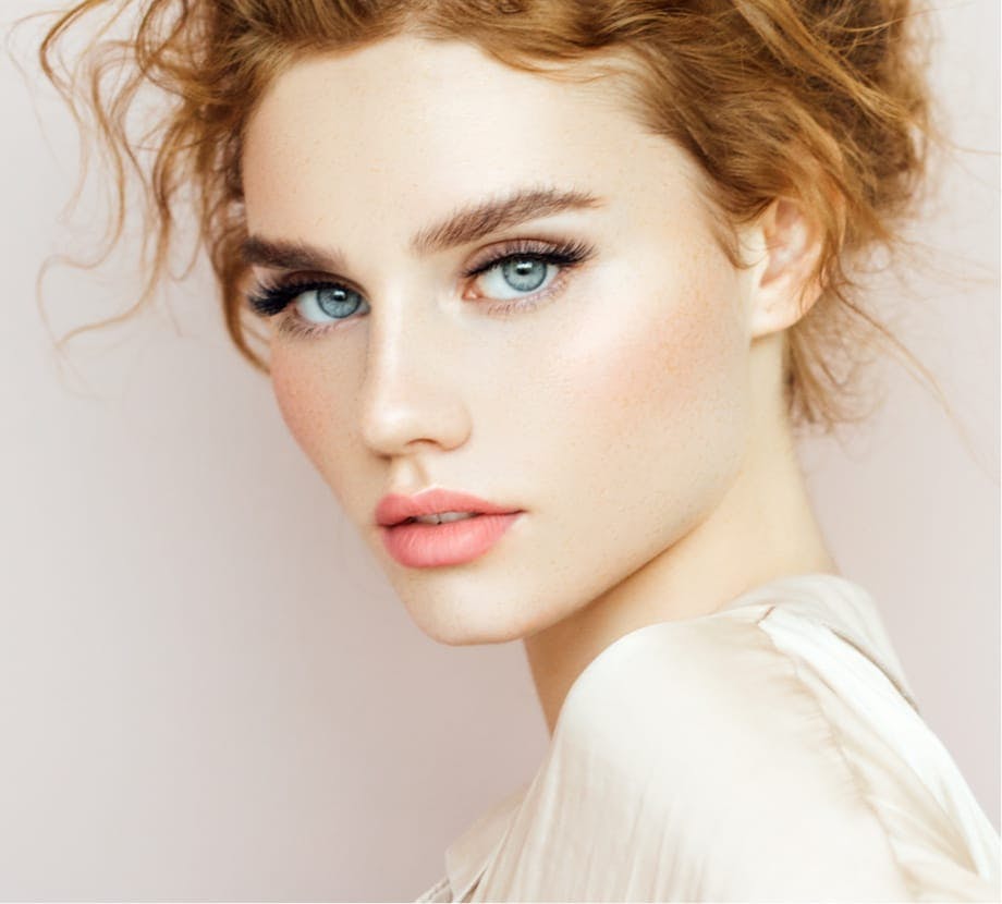 Woman with red curly hair in an updo