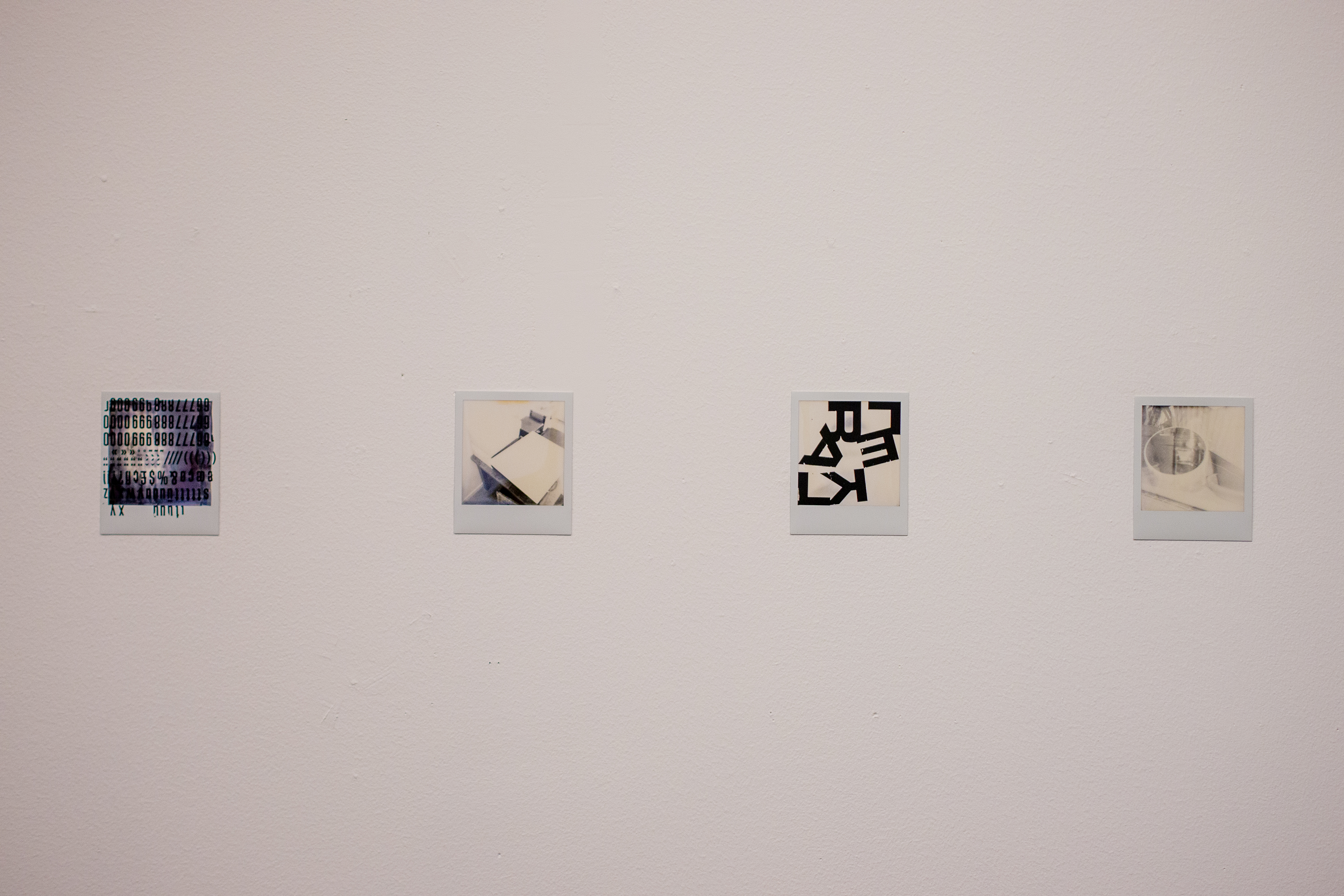 Fyra polaroidfoton sitter på rad på en vit vägg, fotade rakt framifrån. Fotografierna föreställer bland annat en blomkruka och ett köksbord. Två av dem är bearbetade med bokstäver som t.ex. L, E, A, K, F klistrade ovanpå bilderna. Bokstäverna bildar inga urskiljbara ord.
