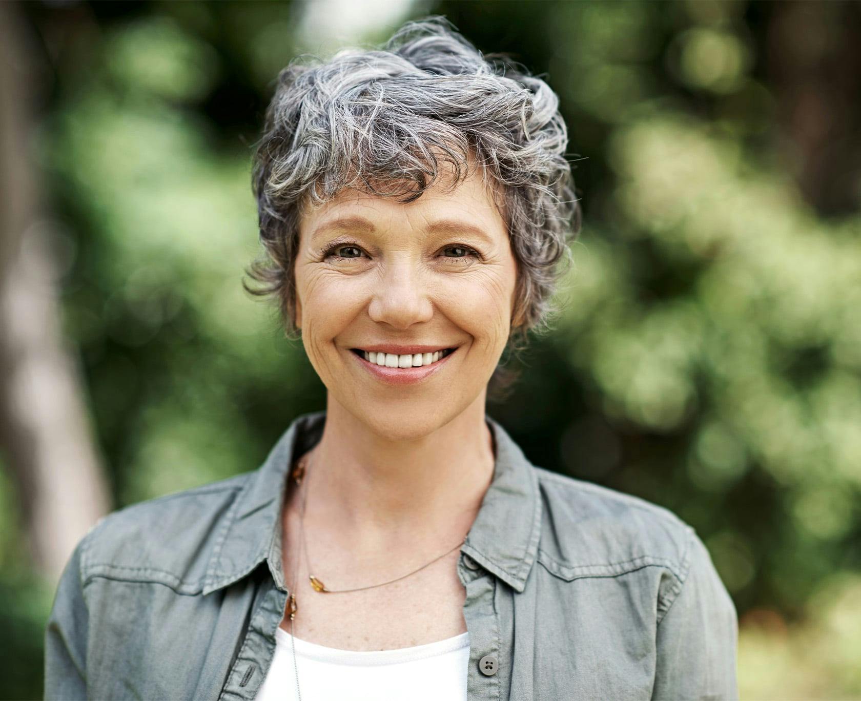 Woman in a sage green shirt smiling
