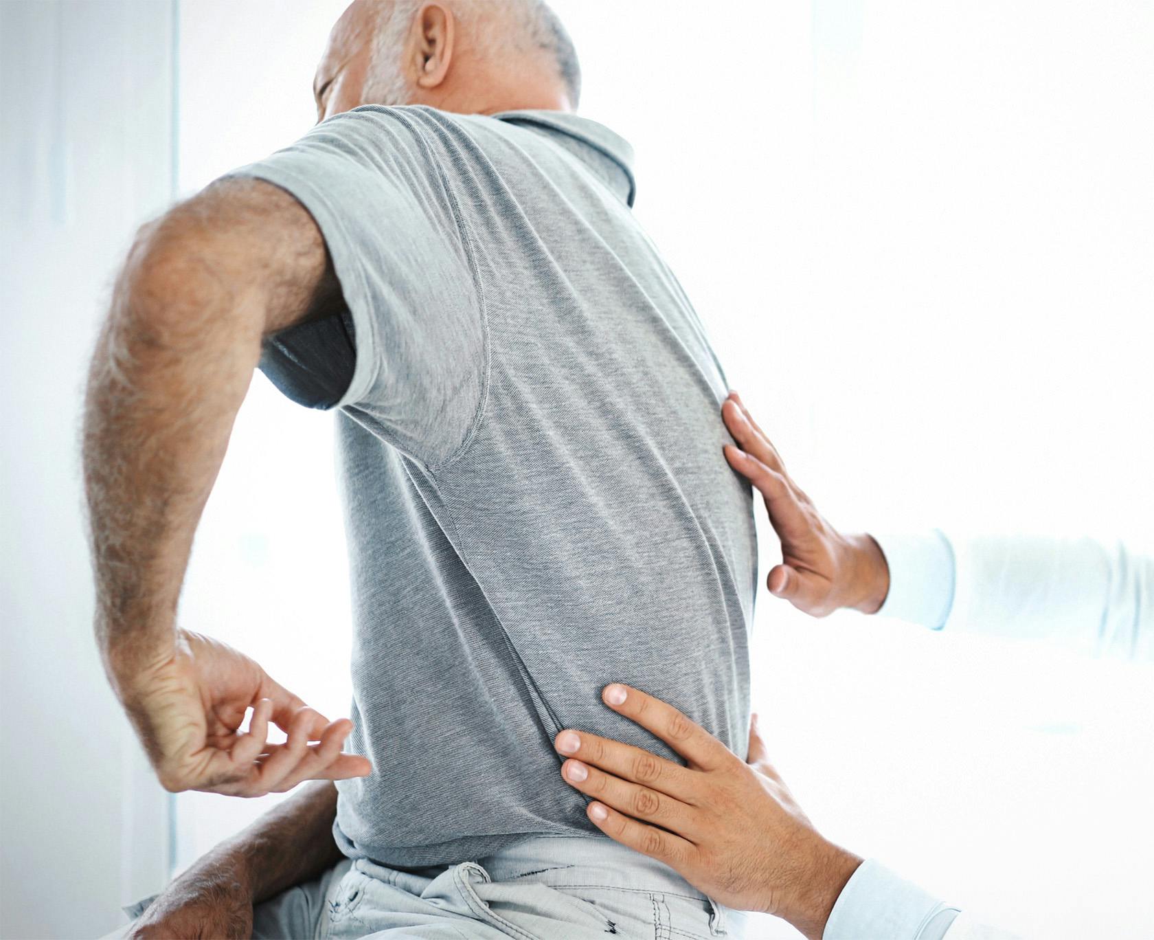 Man getting his lower back checked by a doctor