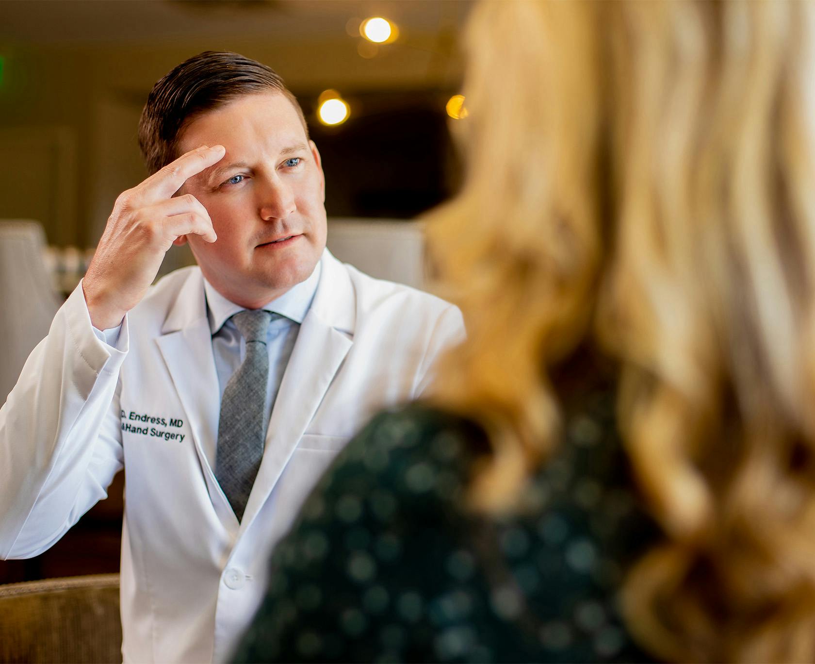 Doctor with his fingers on his forehead talking to a patient