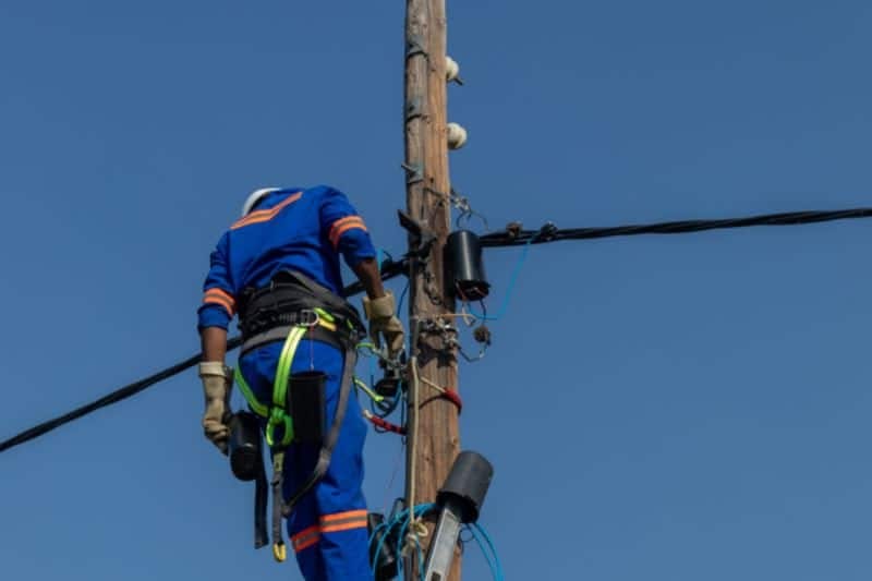 Ouvrier en hauteur travaillant sur une ligne haute tension