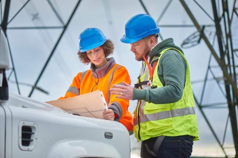 Ouvriers homme et femme sur un chantier préparant une mise en pratique pour la formation habilitation électrique