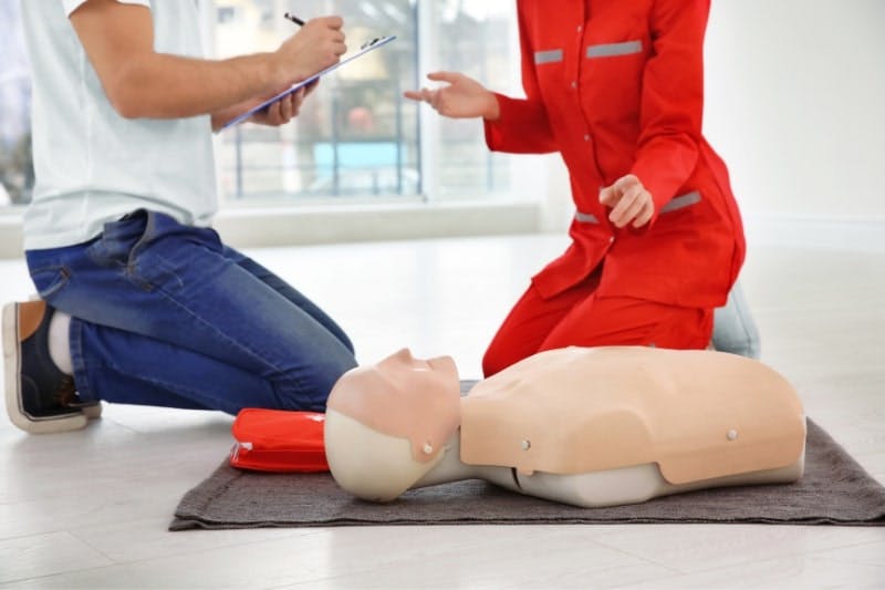 Formateur SST et son élève devant un mannequin dans le cadre du renouvellement de certificat SST