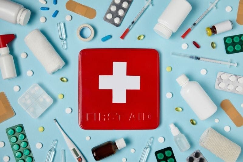 Boite de pharmacie rouge et médicaments symbolisant la santé et la sécurité au travail